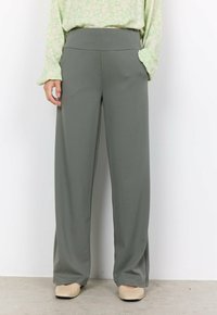 Pantalons à jambières larges en tissu gris doux. Dotés d'une taille haute et de deux poches latérales. Texture lisse avec une coupe décontractée.