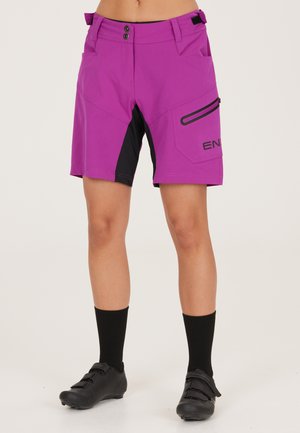 Magenta shorts med svarta detaljer, två framfickor, en sidficka med dragkedja och en figurnära design; tillverkade av lätt, hållbart material.