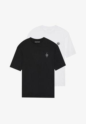 Dos camisetas de manga corta: una negra con un gráfico de serpiente y una blanca con un gráfico de sol. Ambas están hechas de algodón y tienen cuello redondo.