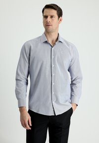 Camicia azzurra a maniche lunghe con bottoni, caratterizzata da un sottile motivo a righe, colletto classico e polsini abbottonati. Vestibilità slim con orlo dritto.