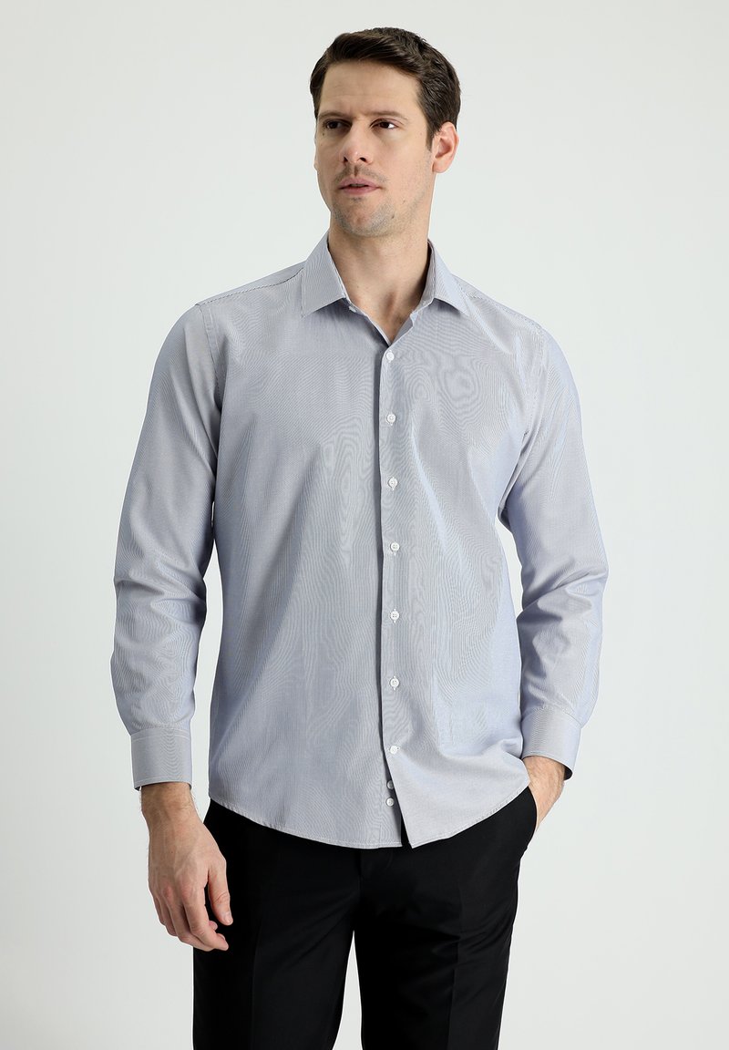 Camicia azzurra a maniche lunghe con bottoni, caratterizzata da un sottile motivo a righe, colletto classico e polsini abbottonati. Vestibilità slim con orlo dritto.