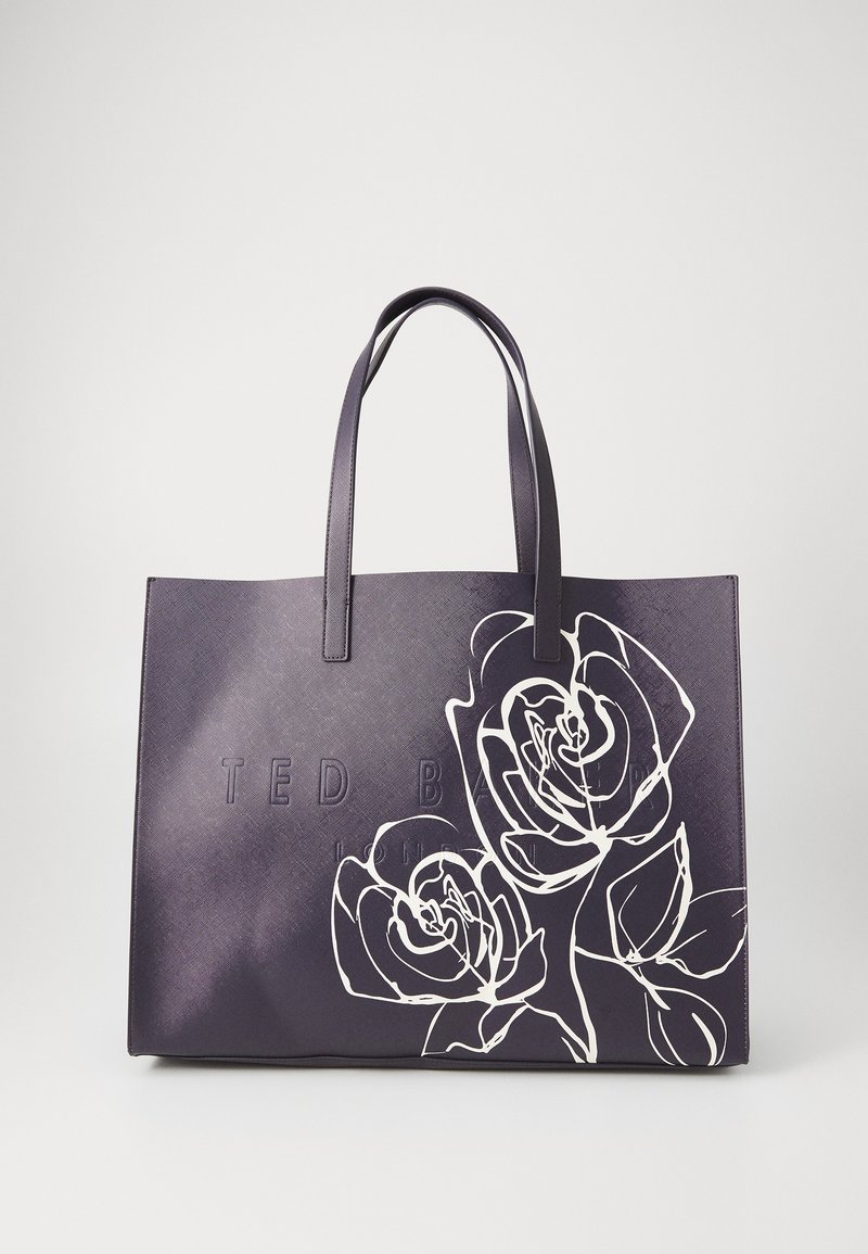 Paarse tote bag met een witte rozenprint en een gegraveerd logo. Beschikt over stevige handvatten en een textuur oppervlak, en biedt een ruime indeling.