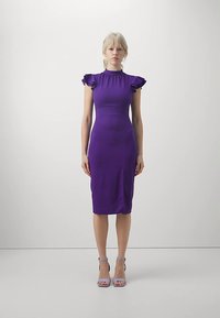 Violeta pieguloša kleita ar volānu piedurknēm, ceļa garuma griezumu un gludu tekstūru. Valkāta ar gaiši violetām augstpapēžu sandales.