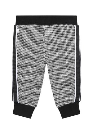 Jogging en noir et blanc à motifs avec une texture en maille, dotés d'une taille noire et de bandes sur les côtés. Les poignets aux chevilles complètent le design.