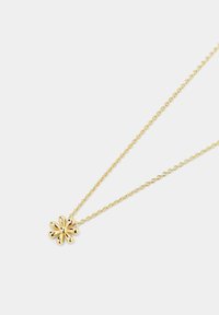Collana d'oro con un ciondolo a forma di fiore texturizzato, attaccata a una catena attorcigliata. Il fiore ha petali arrotondati, creando un effetto tridimensionale.