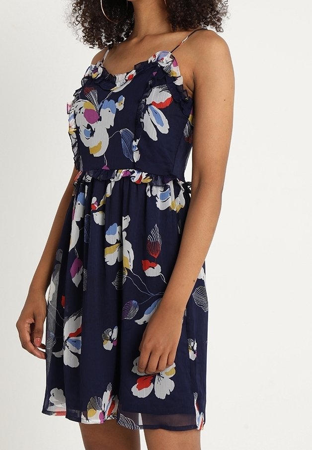 Robe à imprimé floral en tissu bleu marine, avec des bretelles volantées, un corsage ajusté et une jupe évasée ornée de motifs floraux colorés.