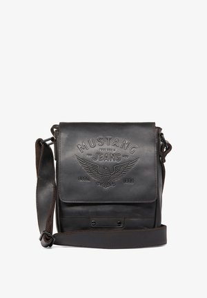 Brown leather messenger bag with embossed "Mustang Jeans" logo, snap closure, adjustable strap, smooth texture, and minimalist design.