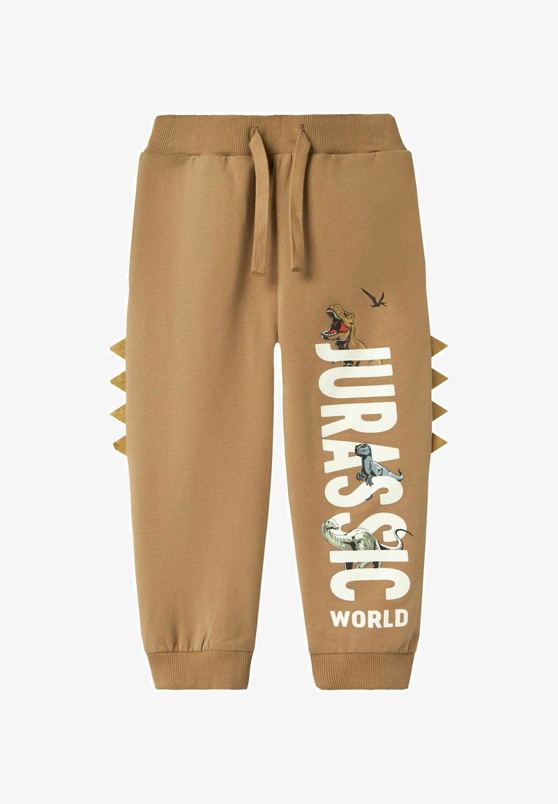 Kreemjad joggersid reguleeritava vöökohtaga, millel on dinosauruste graafika ja valge kiri "JURASSIC WORLD". Küljel olevad aktsendid meenutavad okkaid.