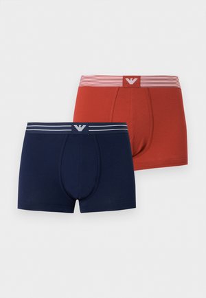 Dos pares de bóxers para hombres, uno azul marino con cinturilla a rayas blancas, otro rojo óxido con cinturilla a rayas rojas y blancas, ambos con logo en el centro delantero.