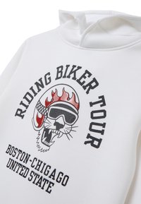 Sudadera blanca con un diseño gráfico de una calavera estilizada con gafas de sol y llamas, etiquetada "TOUR DE MOTEROS" y detalles de la ubicación debajo.