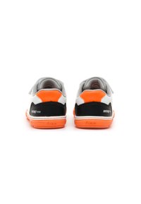 Zapatillas blancas con acentos en naranja y negro, que cuentan con una suela texturizada y correas de Velcro. Diseño limpio con un branding minimalista en el talón.