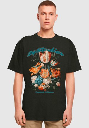 Sort bomulds t-shirt med et floralt design i orange, blå og hvid. Teksten "Fragant Whispers" i turkis over blomsterne.