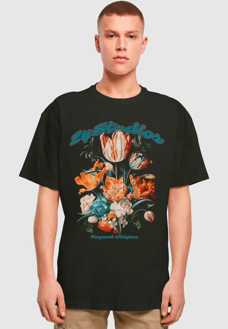 Svart bomulls t-skjorte med blomsterdesign i oransje, blått og hvitt. Tekst "Fragant Whispers" i turkis over blomstene.