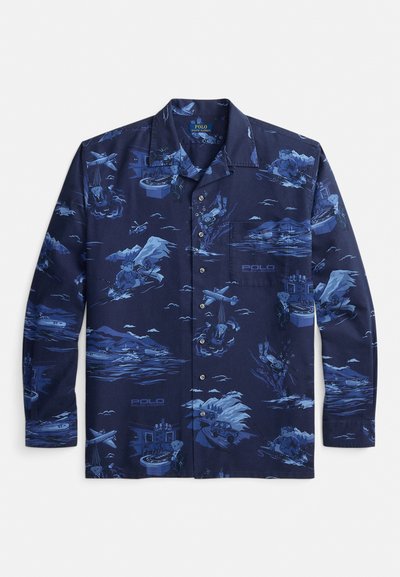 Μπλε πουκάμισο με κουμπιά σε ναυτικό μπλε χρώμα, με μπλε σχέδια από αρκούδες που συμμετέχουν σε διάφορες δραστηριότητες: σκι, καταδύσεις, οδήγηση, παίζοντας ρουλέτα και πιλοτάρισμα αεροπλάνων.