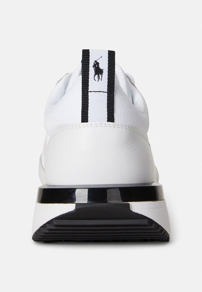 Λευκό αθλητικό αθλητικό παπούτσι με υφασμένο επάνω μέρος από πλεκτό δίχτυ, μαύρη ρίγα ως διακόσμηση και γυαλιστερό μαύρο πίσω μέρος πλατφόρμας. Διαθέτει λογότυπο στην πίσω ετικέτα.