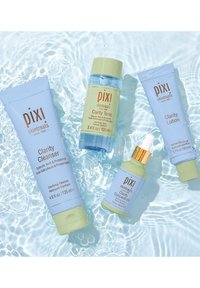 Quattro prodotti skincare di Pixi: un tubo blu di Clarity Cleanser, una bottiglia verde di Clarity Tonic, un siero giallo e una lozione blu di Clarity.