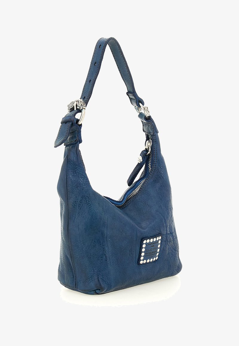 Borsa a tracolla in pelle blu con silhouette curva, chiusura con zip e un elemento decorativo quadrato con strass. Tracolla regolabile per maggiore versatilità.