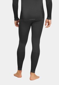 Czarne leginsy termiczne o gładkiej teksturze, dopasowanym fasonie i prążkowanych akcentach na dolnych partiach nóg. Na pasku znajduje się nazwa marki "ALPINUS".