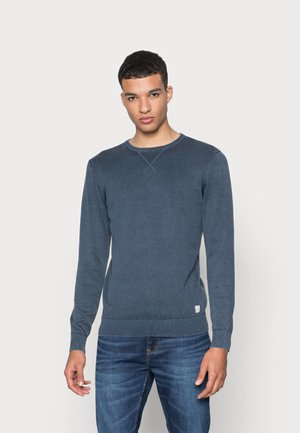Navy blue knit sweater with long sleeves and a round neck. Features ribbed cuffs and hem, with a small logo detail at the bottom.