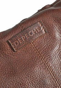 Borsa in pelle marrone con superficie texturizzata, cuciture visibili e una patch in pelle con il marchio "DEPECHE."