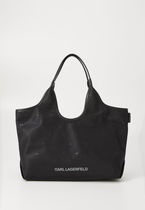 Black tote bag with a matte finish, featuring embossed logo patterns and a silver "KARL LAGERFELD" branding at the bottom. Smooth texture.