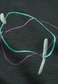 Tessuto nero con linee curve in verde bluastro e viola, con una texture liscia e una leggera lucentezza, che crea un motivo moderno.