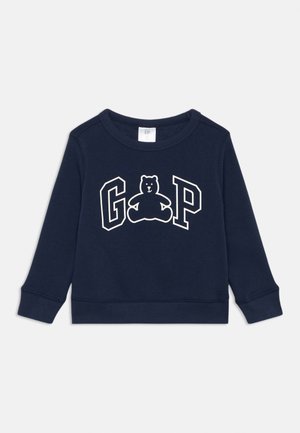Marineblaue Sweatshirt mit rundem Halsausschnitt, langen Ärmeln, gerippten Bündchen und einem Grafikdruck eines Bären mit "GAP"-Schriftzug in Weiß auf der Vorderseite.