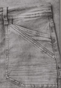 Gros plan sur la poche d'un jean en denim gris avec double surpiqûre, passants de ceinture, rivet et texture visible du tissu.