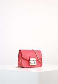 Rosa Leder-Crossbody-Tasche mit strukturiertem Finish, goldfarbigem Kettenriemen und einem rechteckigen Magnetverschluss.