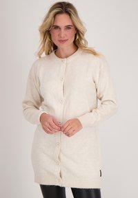 Beige gebreide cardigan van zachte stof, met een ronde halslijn, lange mouwen en een sluiting met grote knopen aan de voorkant.