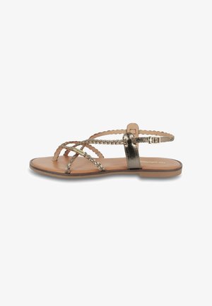 Sandali con cinturini intrecciati in metallo, una soletta liscia color tan e una chiusura con fibbia minimalista. Suola piatta per una facile vestibilità.