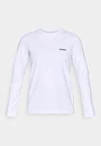 Duge rukavi bijela pamučna majica s okruglim izrezom i crnim "patagonia" logotipom na lijevoj strani prsnog koša. Glatka tekstura, klasičan kroj.