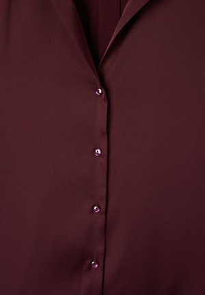 Burgundowa bluzka zapinana na guziki z gładkiego, błyszczącego materiału. Posiada klasyczny kołnierzyk i sześć błyszczących guzików z przodu. Prosty i elegancki design.