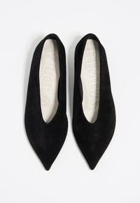 Ballerine nere in suede con punta appuntita, dotate di un interno liscio e un design a scollo basso. Presentano un logo impresso in modo discreto sulla soletta.