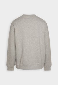 Sudadera gris con cuello redondo, mangas largas y puños acanalados. Textura suave y diseño minimalista, sin patrones visibles ni logotipos.