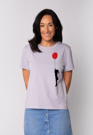 Light purple cotton t-shirt featuring a black silhouette of a person holding a red balloon, short sleeves, and a relaxed fit.