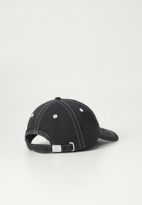 Căciulă de baseball neagră din bumbac, cu cusături albe, bărbie curbată, ochiuri de ventilație și o curea ajustabilă în spate.
