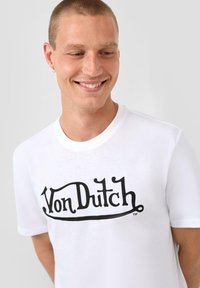 Witte katoenen t-shirt met een opvallend zwart "Von Dutch" logo in een vet, gebogen lettertype. Korte mouwen en een ronde hals.