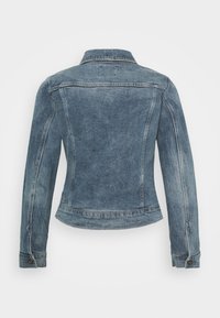 Chaqueta de mezclilla en azul claro con un corte clásico. Presenta un cuello puntiagudo, puños abotonados y una textura de desvanecimiento sutil en la tela.