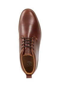 Brown leather shoe with a smooth finish, rounded toe, and structured upper. Features black laces and a pull tab on the heel.