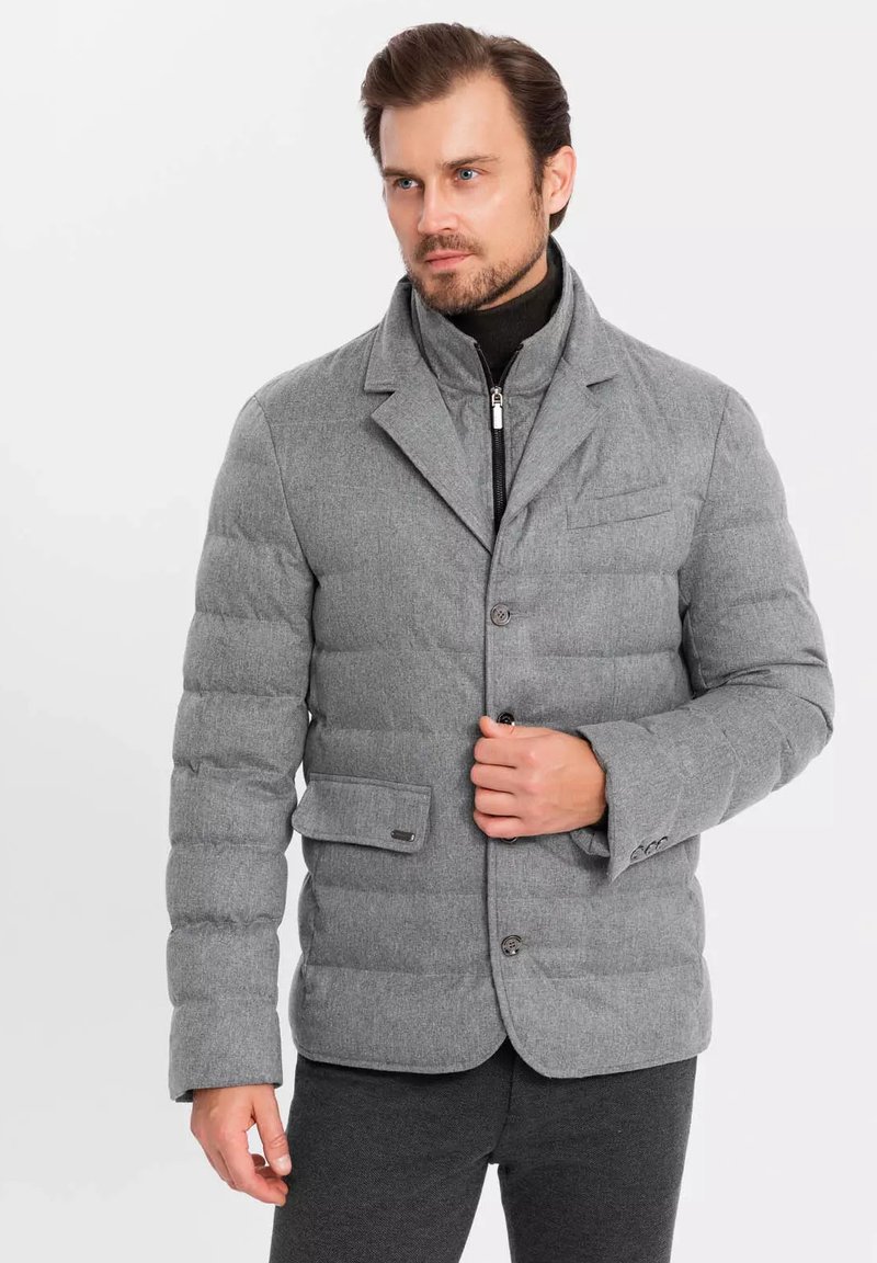 Chaqueta gris acolchada con dise�ño de blazers, que presenta un cuello con muesca, botones frontales y un bolsillo en el pecho, fabricada en tejido texturizado.