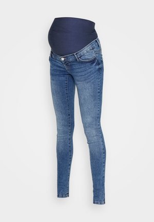 Jeans de maternité avec une taille élastique bleu foncé, en denim bleu clair, coupe skinny et décoloration subtile sur les jambes sans ornements.
