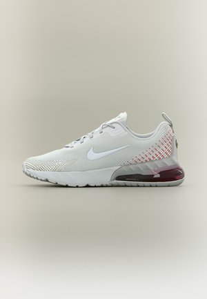Valkoinen Nike Air Max -juoksukenkä, jossa on harmaat ja vaaleanpunaiset liukuvärjäystiedot sekä näkyvä ilmatyyny pohjassa.