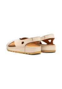 Beżowe skórzane sandały z otwartymi bokami, posiadające wycięcia, wyściełaną wkładkę oraz grubą, fakturowaną podeszwę.