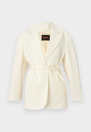 Kremowy damski żakiet z wyciętymi klapami, długimi rękawami, dwoma przednimi kieszeniami i paskiem do wiązania w pasie, z metką BOSS wewnątrz kołnierza.