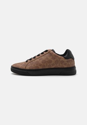 Sneakers maro cu un model si o suprafață texturată, talpă din cauciuc negru și accente negre pe călcâi și gauri pentru șireturi. Sunt prezente șase șireturi negre.