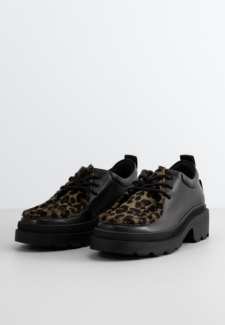 Chaussures noires en cuir avec un panneau avant à imprimé léopard, bouts ronds, épais semelles noires et textures contrastantes. Design à lacets avec un talon surélevé.