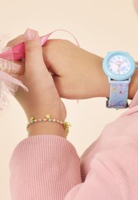 Hellblaues Uhr mit einem Blumenmuster-Armband; verfügt über ein rundes Ziffernblatt und Markierungen. Bunte Perlenarmband mit goldenen Herz-Anhängern.