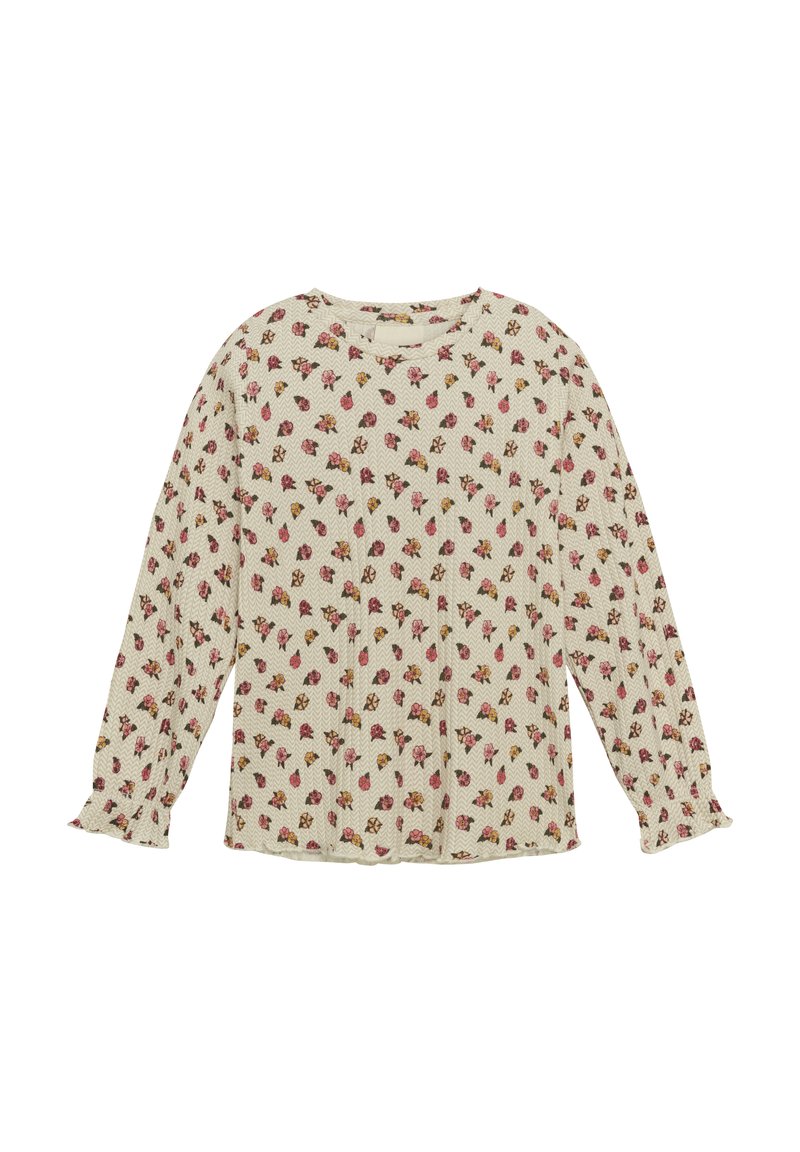 Långärmad blus i krämfärg med ett mönster av blommor i rosa och gult över hela. Har rund halsringning och rynkade manschetter. Strukturerad tyg.