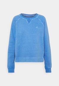 Sudadera azul con cuello redondo y puños acanalados texturizados, con un pequeño logo en el pecho. Tela suave con un ajuste relajado.